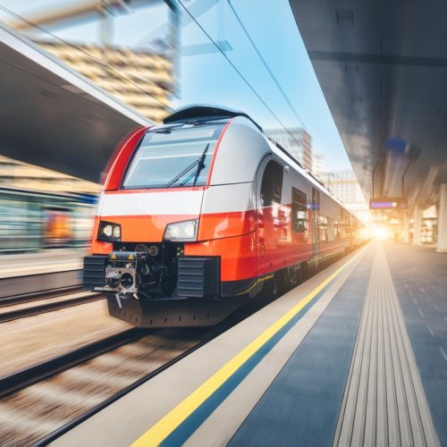 High-speed,Orange,Passenger,Train,Moving,At,Railway,Station,Platform,At